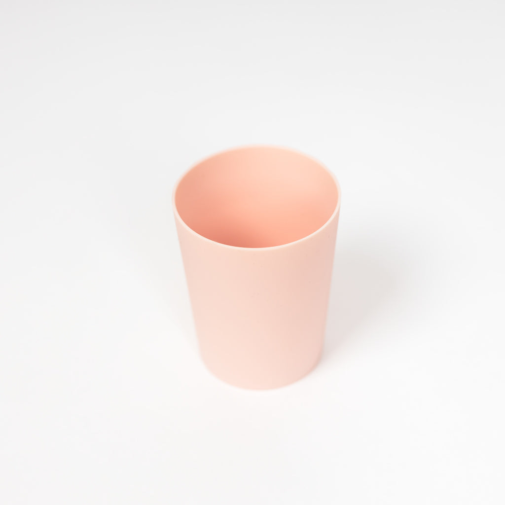 Toddler silicone cup in blush on white background.
