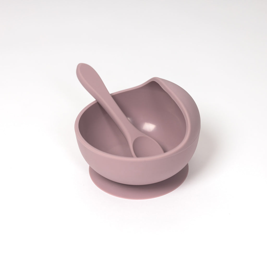 image of 100% food grade silicone bowl and spoon set in pale mauve. Toddler sized spoon sits in suction bowl that features a curved lip to help with scooping purees