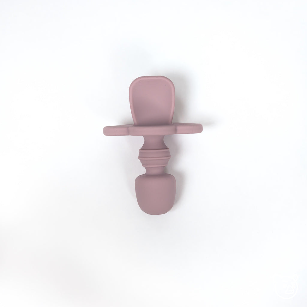 top image of silicone toddler training spoon in pale mauve. Spoon is made from 100% food grade silicone has a thick short handle to make holding easy and a cloud shaped stopper beneath the soft spoon lip to help prevent gagging as baby learns to eat