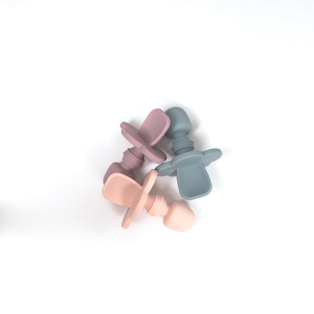 Image of 3 infant toddler spoons from 100% food grade silicone in blush pink, pale blue and mauve.