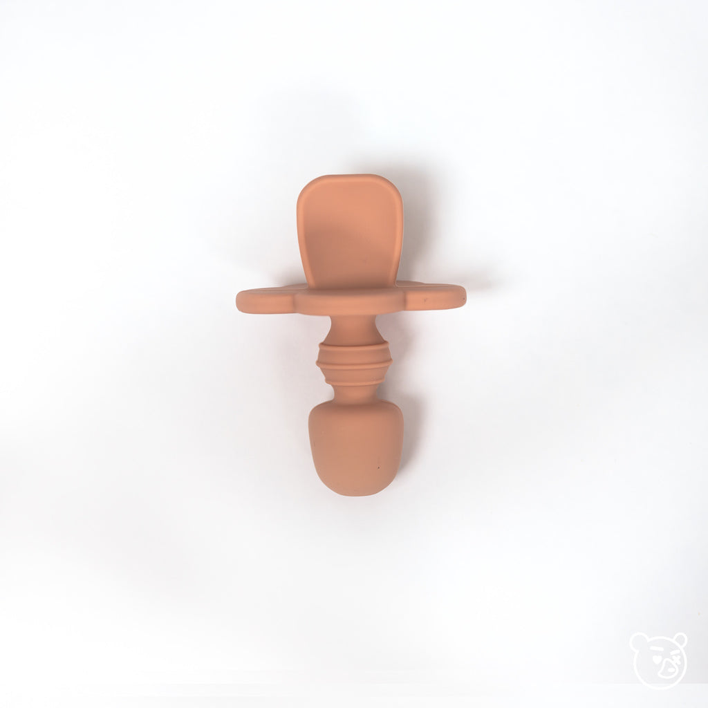top image of silicone toddler training spoon in terracotta. Spoon is made from 100% food grade silicone has a thick short handle to make holding easy and a cloud shaped stopper beneath the soft spoon lip to help prevent gagging as baby learns to eat