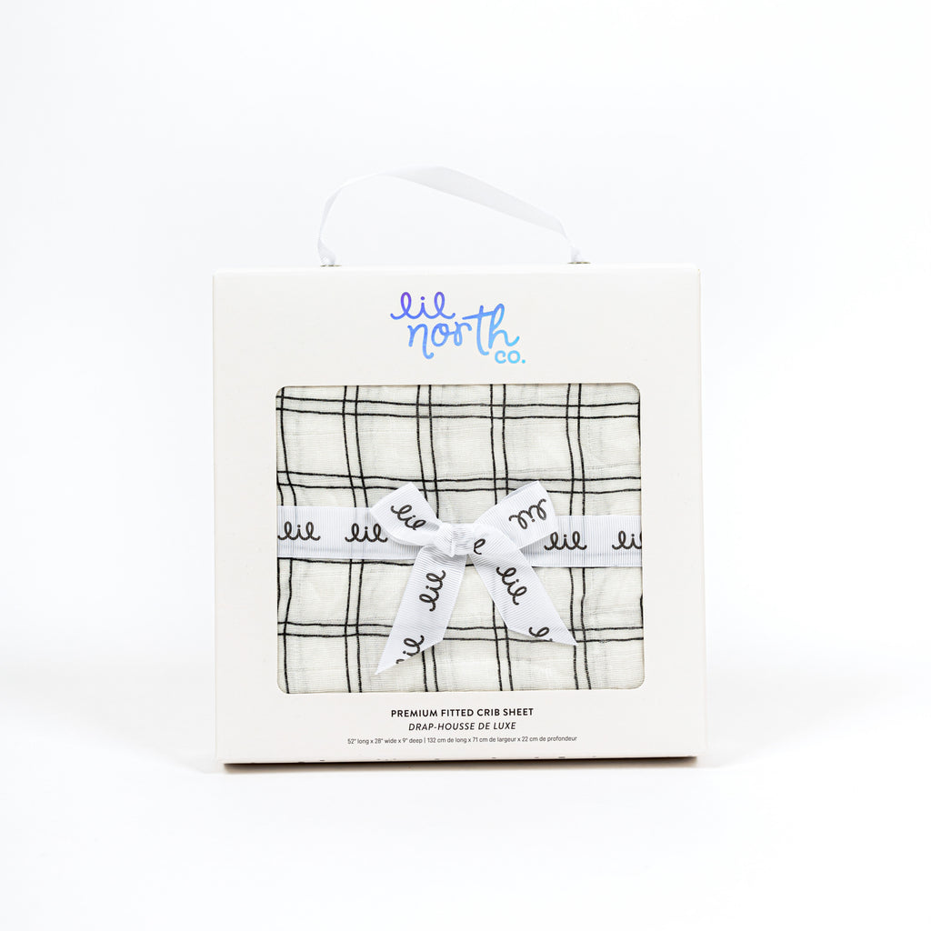 Perfectly packaged white box with ribbon and lil north co label. Featuring premium bamboo cotton muslin black and white grid crib sheet inside