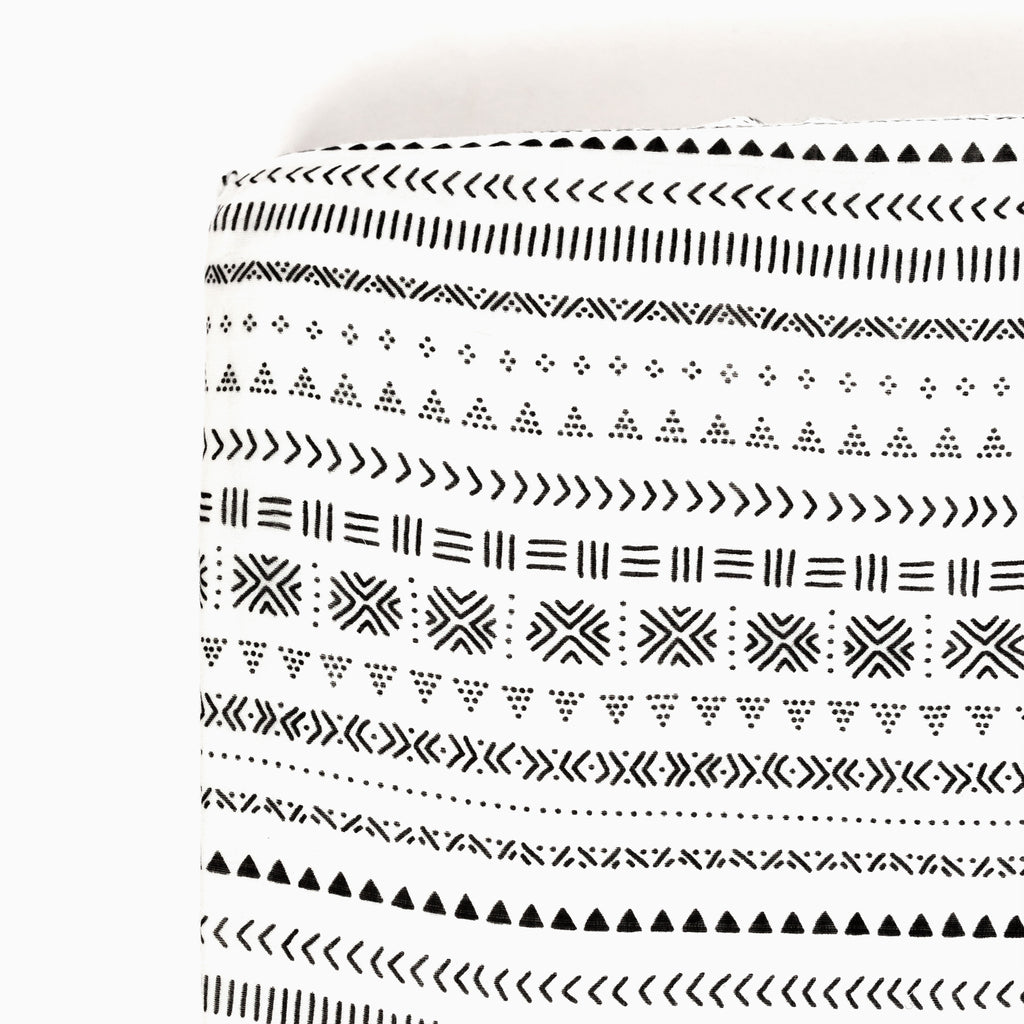 corner image of premium bamboo cotton muslin crib sheet featuring black and white tribal print