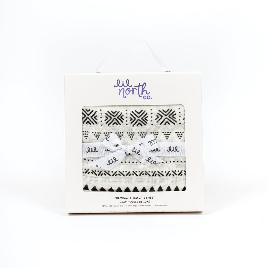 perfectly packaged black and white tribal bamboo cotton muslin crib sheet in white box with lil north co logo and ribbon tied in a bow