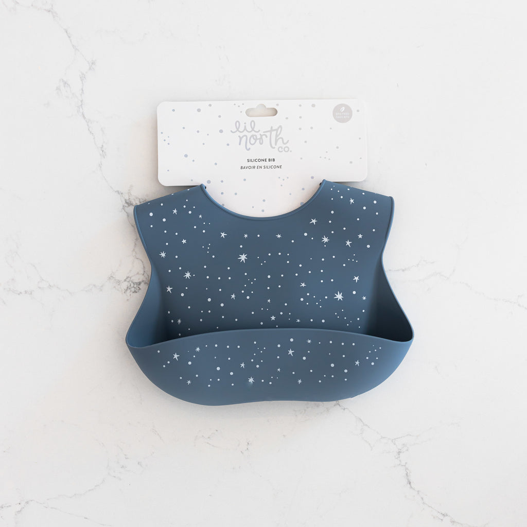 Safety tested silicone bib in slate blue with tossed twinkle stars in white.
