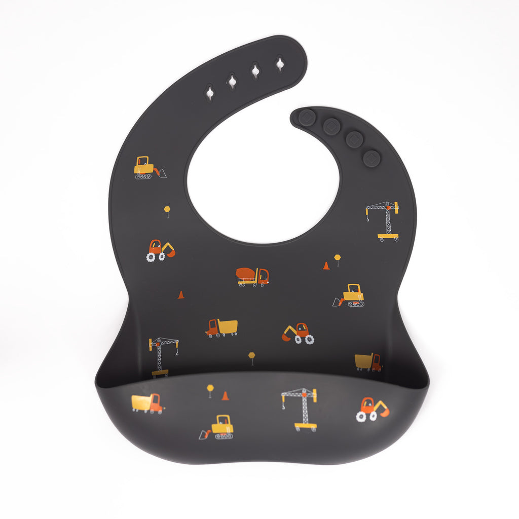 Silicone bib in charcoal with ditsy construction trucks print in yellow orange and white.
