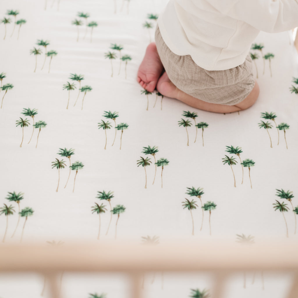 image of little feet on a palm tree printed muslin crib sheet