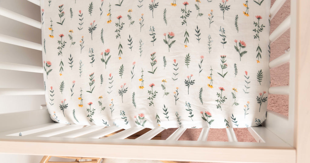 close up image of boho wildflower crib sheet in the corner of a crib