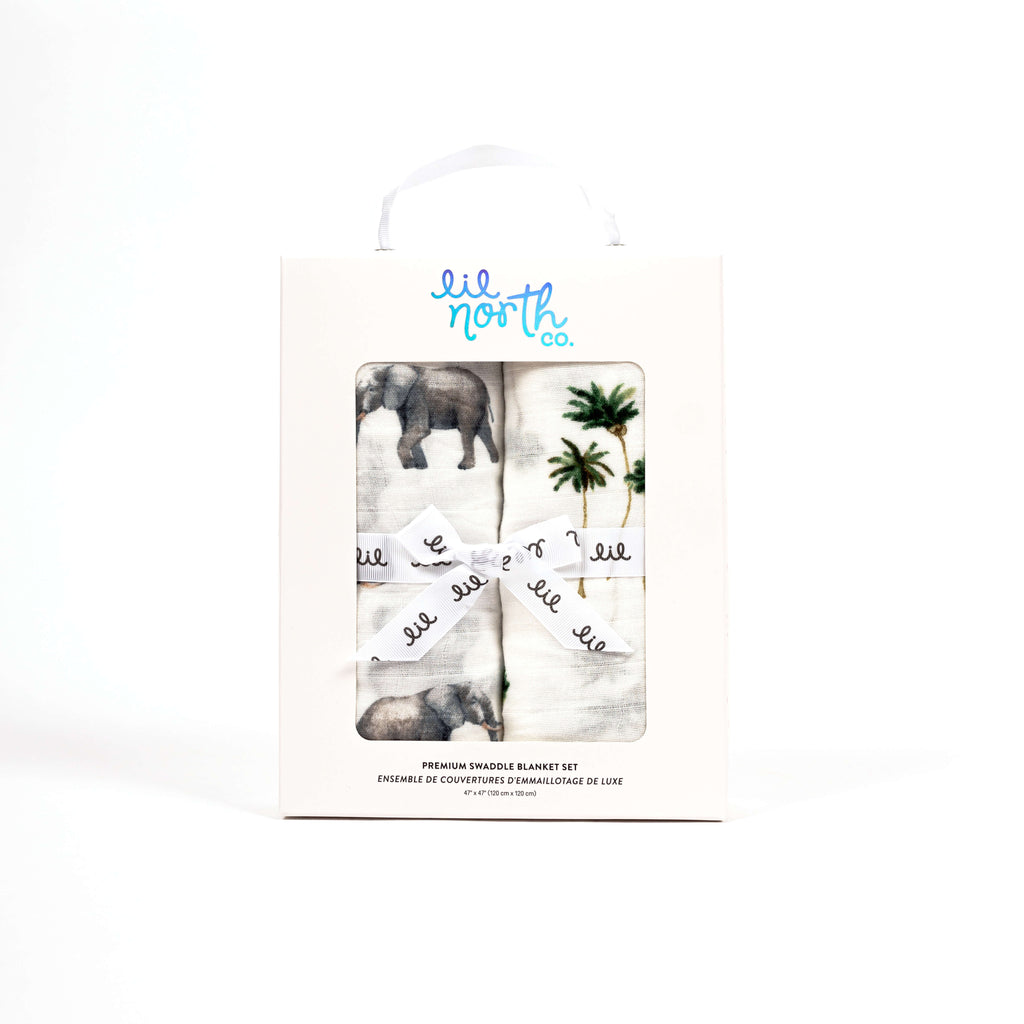 Boxed swaddle set perfect for baby shower or newborn gift. White boxed muslin blankets with one elephant print and one palm tree print