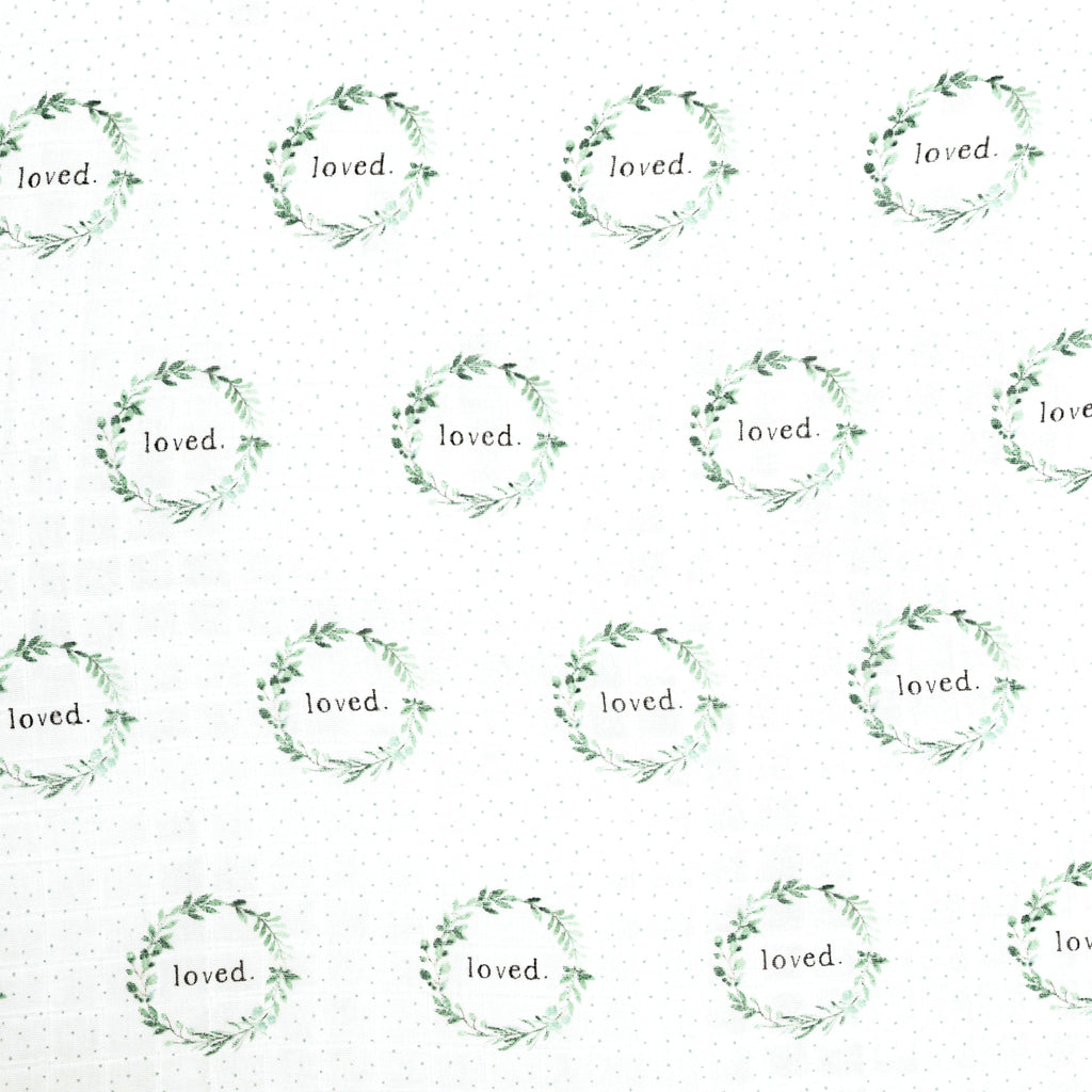 close up image of watercolour sage and green foliage wreath with loved typed in the middle, sage dots tossed in the background. Printed on muslin crib sheet