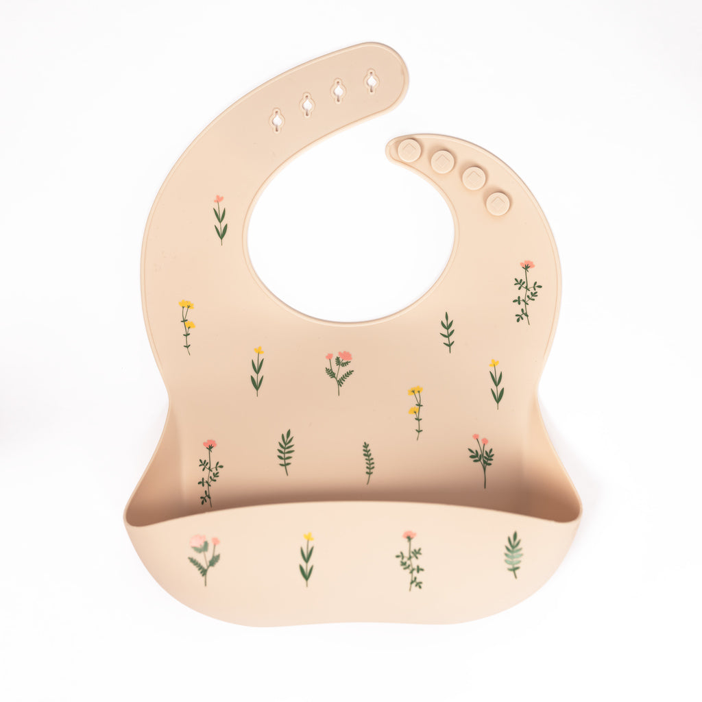 safety tested silicone bib in sand colour with tossed wildflower print in blush yellow and green